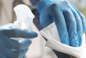 Woman in latex gloves cleaning railing with wet wipe and deterge sanitation